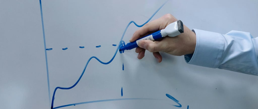 Pessoa planejando objetivos financeiros reais em caderno com calculadora