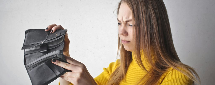 Pessoa preocupada olhando conta bancária - decisões financeiras que drenam dinheiro